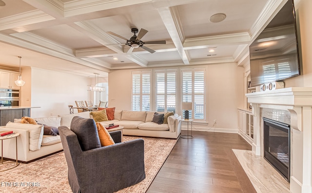 living room featuring beamed ceiling, wood-type flooring, coffered ceiling, a premium fireplace, and ornamental molding