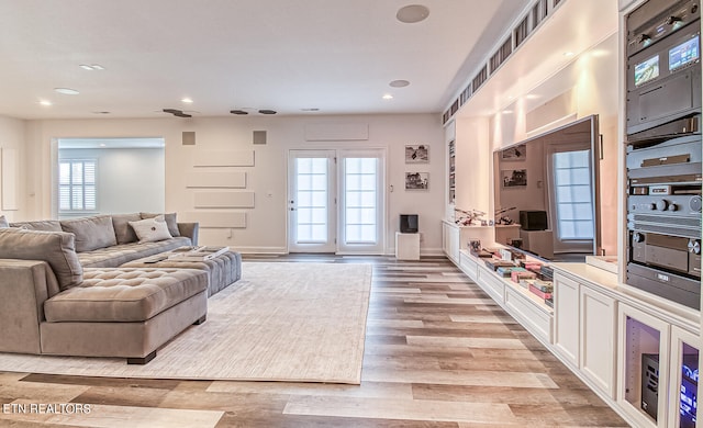 living room with french doors and light wood-type flooring