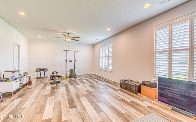 workout room featuring ceiling fan and light hardwood / wood-style floors