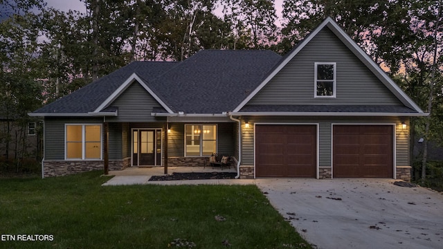 craftsman house featuring a garage and a lawn