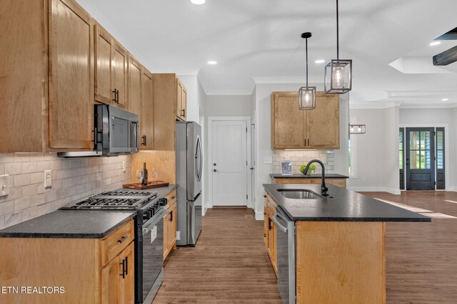 kitchen featuring hanging light fixtures, sink, hardwood / wood-style flooring, stainless steel appliances, and crown molding