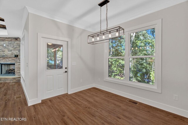 unfurnished dining area featuring a fireplace and dark hardwood / wood-style flooring