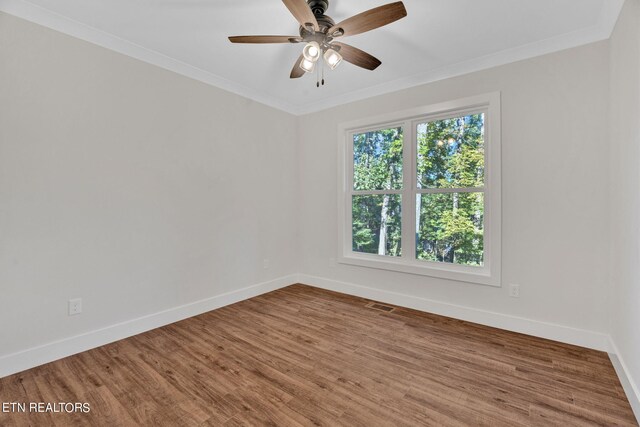 spare room featuring wood-type flooring, ornamental molding, and ceiling fan