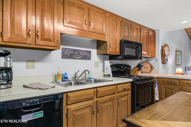 kitchen featuring black appliances, sink, and a textured ceiling