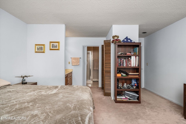 carpeted bedroom with connected bathroom and a textured ceiling