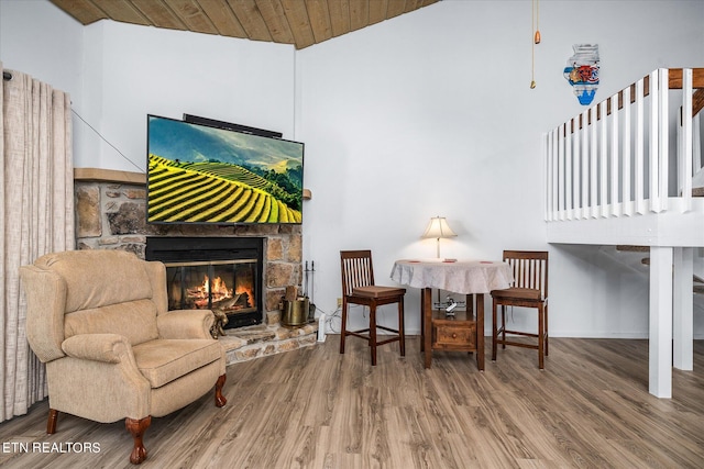 living area with wood-type flooring, wood ceiling, a fireplace, and high vaulted ceiling