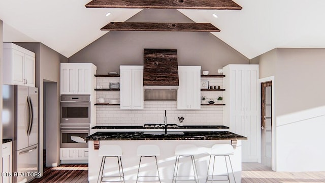 kitchen featuring white cabinets, appliances with stainless steel finishes, hardwood / wood-style floors, and a kitchen breakfast bar