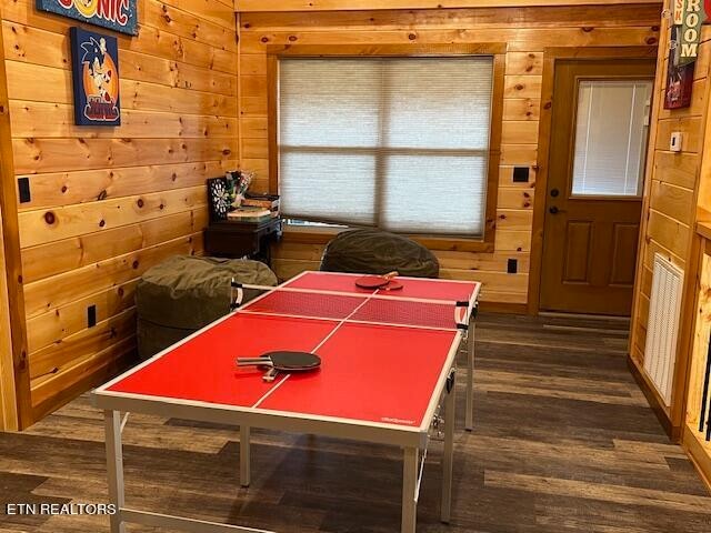 recreation room with wood walls and dark hardwood / wood-style floors