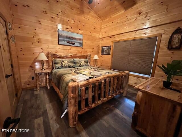 bedroom featuring wood walls, dark hardwood / wood-style floors, and vaulted ceiling