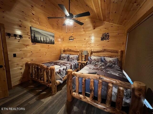 bedroom with ceiling fan, dark wood-type flooring, wood walls, and vaulted ceiling