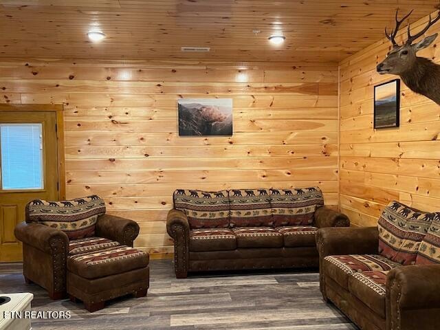 interior space featuring wood-type flooring, wood walls, and wooden ceiling