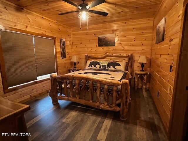 bedroom featuring dark hardwood / wood-style floors, wood ceiling, wooden walls, and ceiling fan