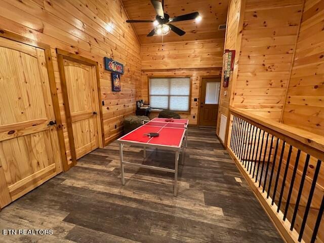 rec room featuring ceiling fan, wood walls, dark hardwood / wood-style floors, wooden ceiling, and vaulted ceiling