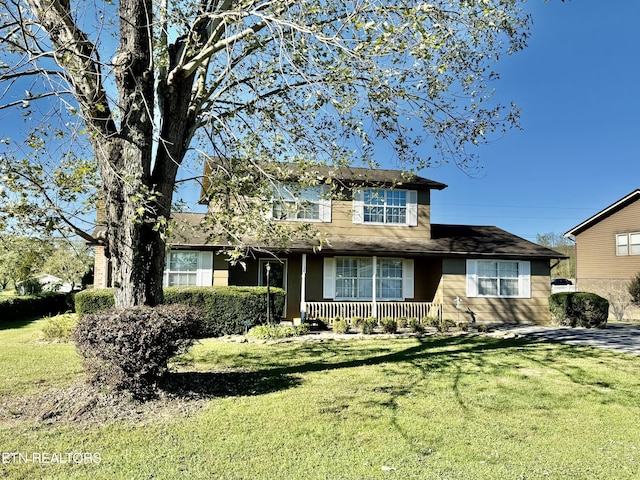 traditional-style home with a porch and a front lawn