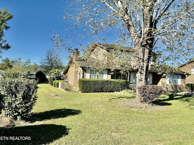 exterior space with central AC, a chimney, and a front lawn