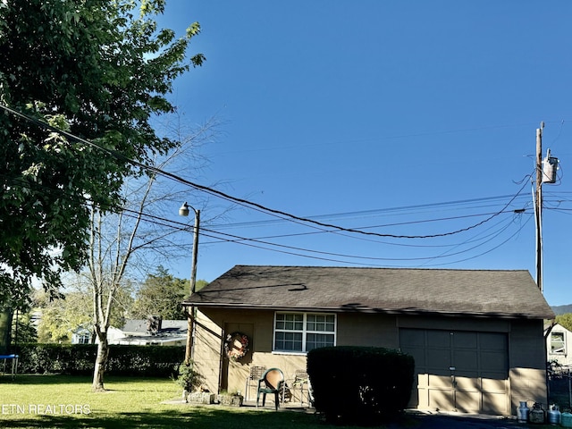 view of property exterior with a garage, a trampoline, a lawn, and roof with shingles