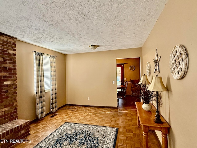 interior space featuring a textured ceiling and parquet flooring