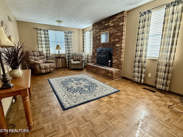 living room with baseboards, a textured ceiling, and visible vents