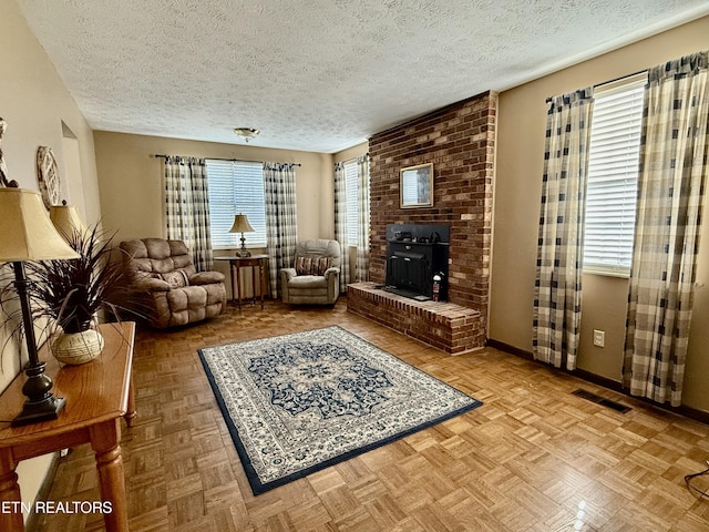 living room featuring a textured ceiling, visible vents, and baseboards