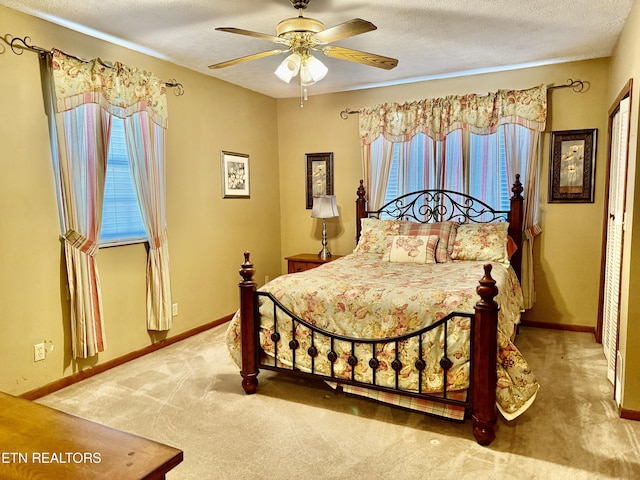 carpeted bedroom with baseboards, a textured ceiling, and ceiling fan