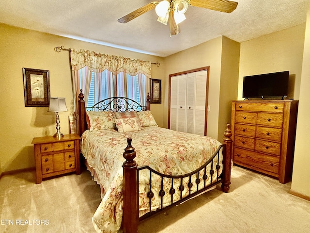 bedroom featuring carpet floors, baseboards, a closet, and a textured ceiling