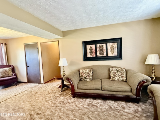 living area with baseboards, carpet flooring, and a textured ceiling