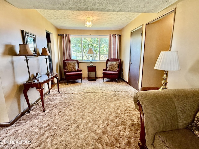 sitting room with a textured ceiling, baseboards, and carpet