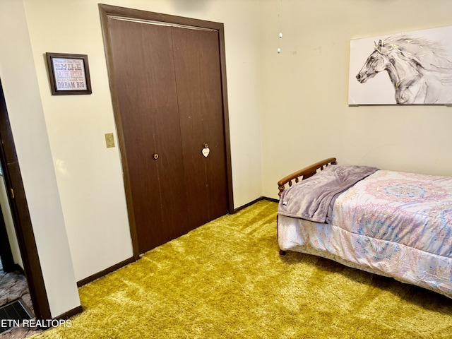 bedroom featuring baseboards, light carpet, and a closet