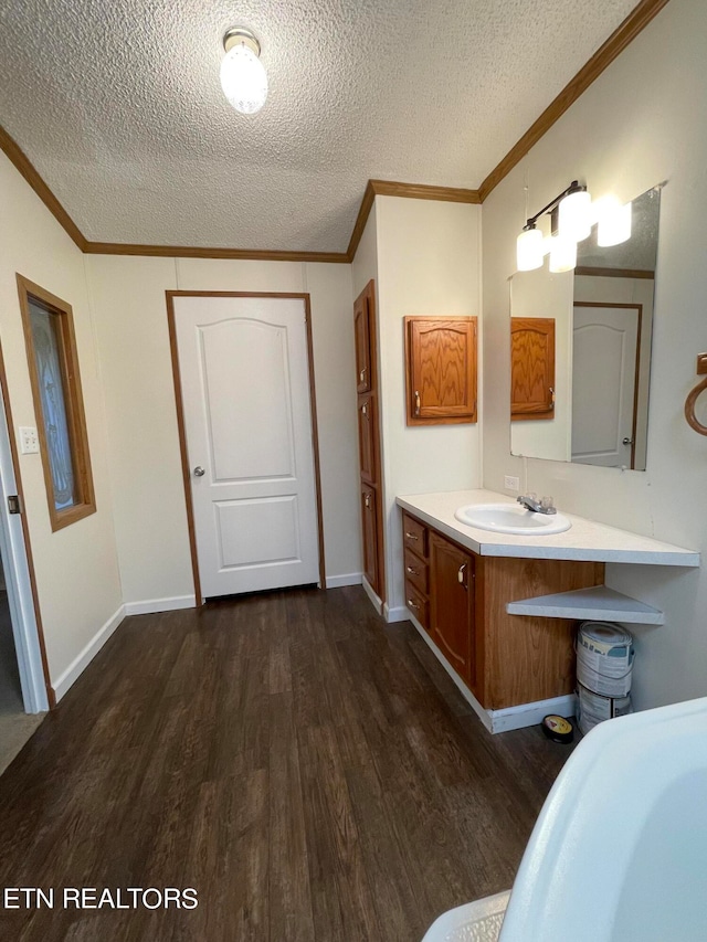 bathroom with vanity, hardwood / wood-style floors, a textured ceiling, and ornamental molding