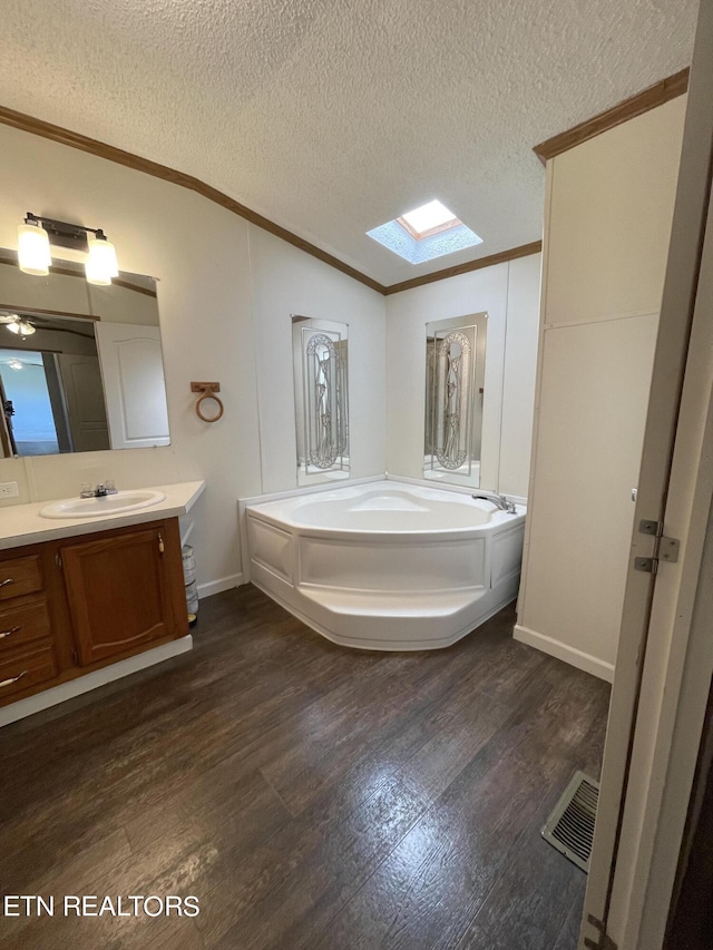 205 Magnolia Ln, Tazewell, TN 37879 - bathroom featuring a skylight, crown molding, wood finished floors, vanity, and a bath
