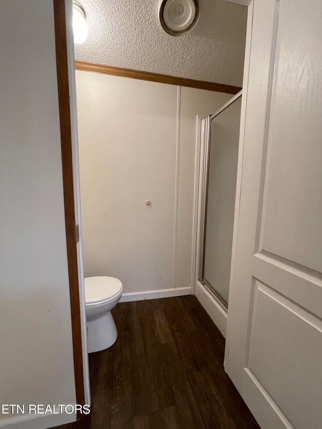 bathroom with toilet, hardwood / wood-style flooring, and walk in shower