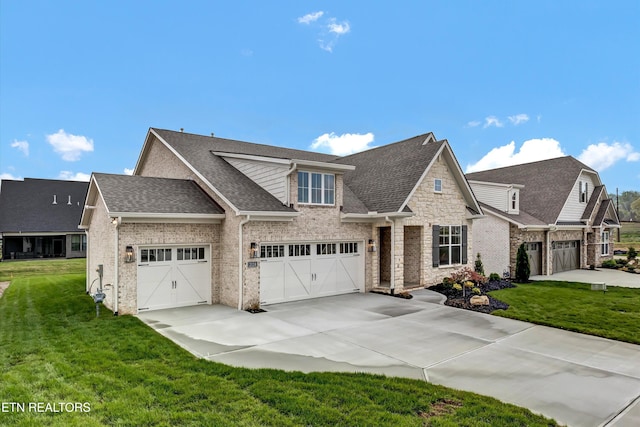 craftsman house featuring brick siding, a front yard, roof with shingles, and driveway