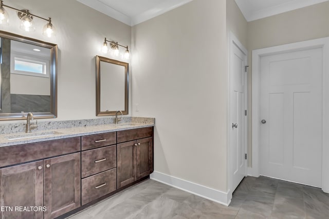 bathroom with double vanity, baseboards, a sink, and crown molding