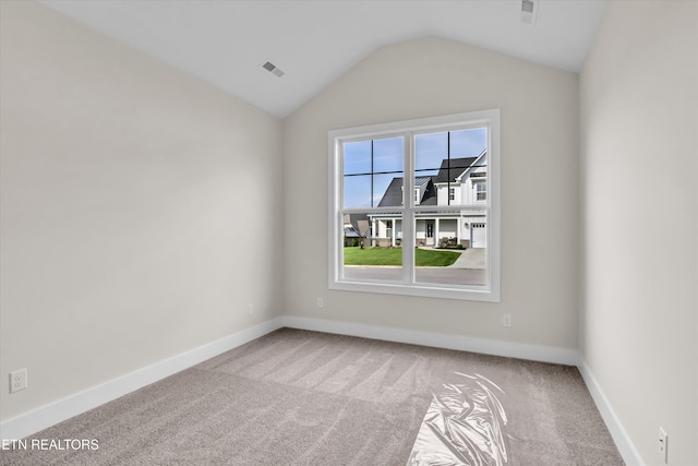 carpeted empty room featuring visible vents, baseboards, and lofted ceiling