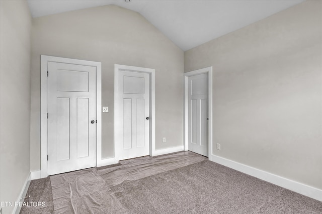 unfurnished bedroom with carpet, baseboards, and vaulted ceiling