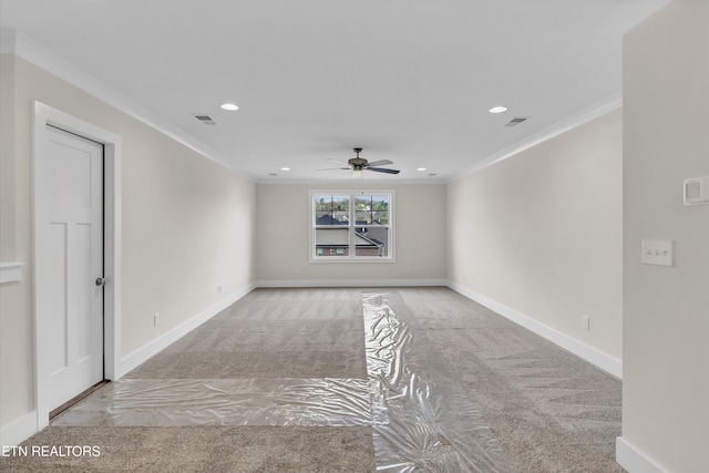spare room with a ceiling fan, ornamental molding, and carpet