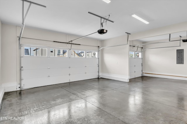 garage with a garage door opener, baseboards, and electric panel