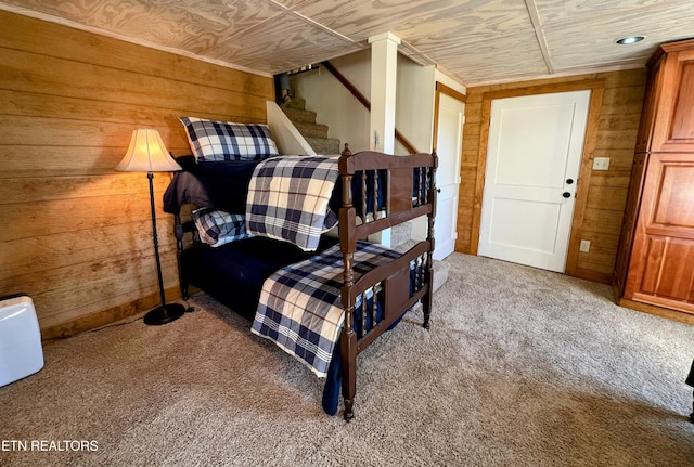 carpeted bedroom featuring wood ceiling and wood walls