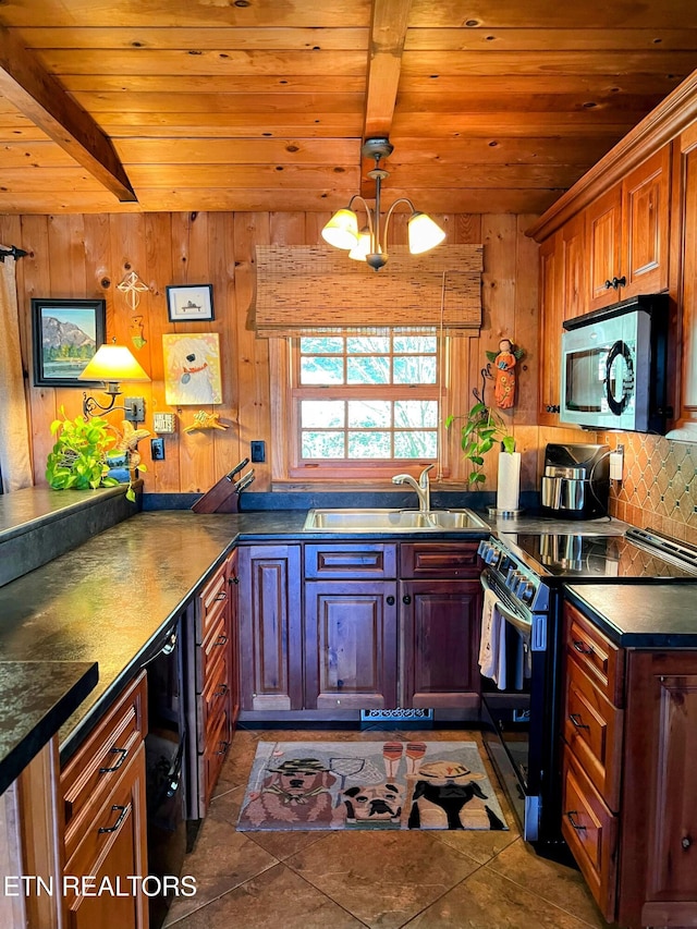 kitchen with dark tile patterned flooring, appliances with stainless steel finishes, sink, wooden ceiling, and wooden walls