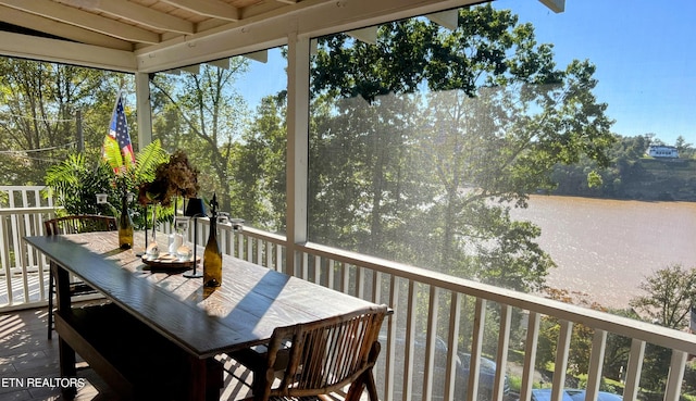 sunroom / solarium with beamed ceiling and a water view