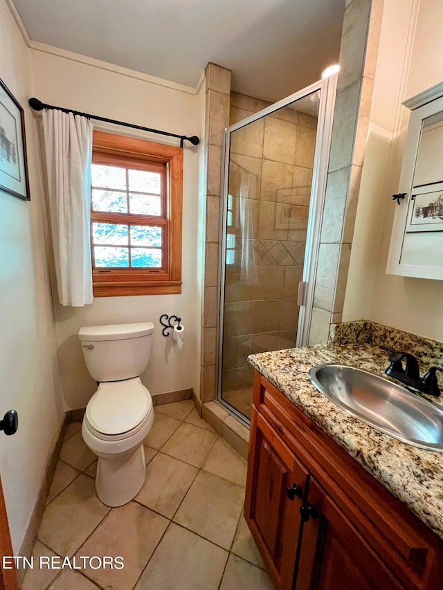 bathroom featuring vanity, tile patterned flooring, toilet, and an enclosed shower