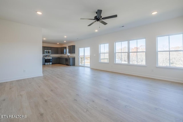 unfurnished living room with ceiling fan and light wood-type flooring