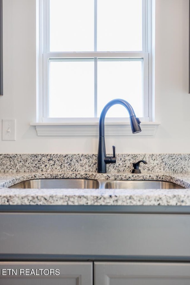 room details featuring light stone counters and sink