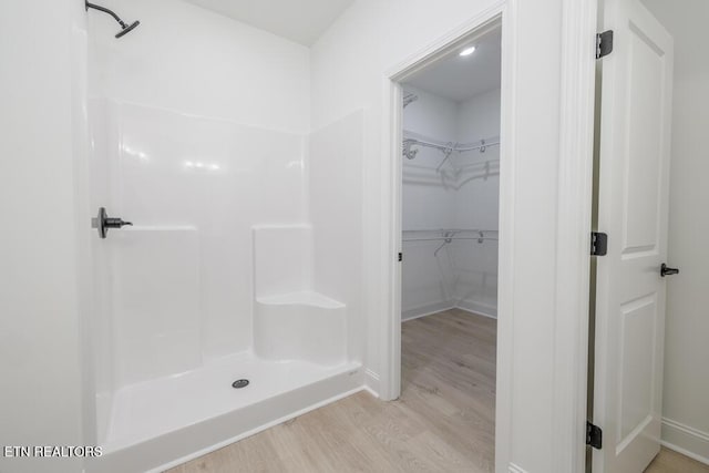 bathroom with hardwood / wood-style flooring and walk in shower