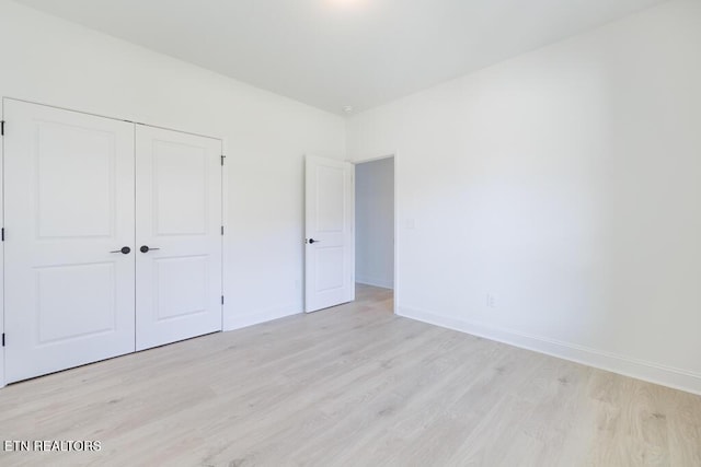 unfurnished bedroom featuring light hardwood / wood-style flooring and a closet