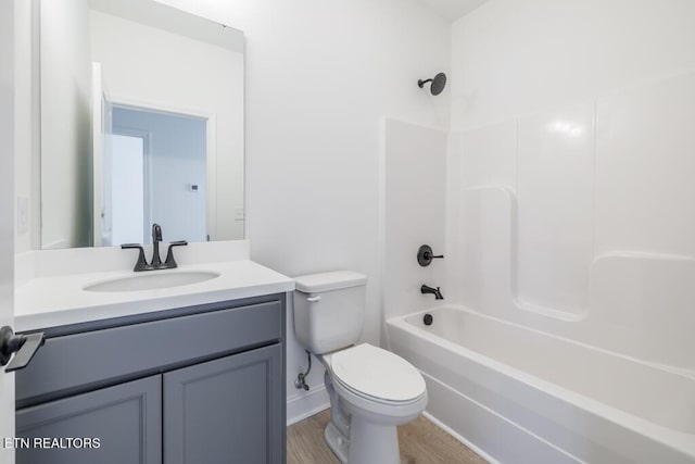 full bathroom featuring hardwood / wood-style flooring, vanity,  shower combination, and toilet