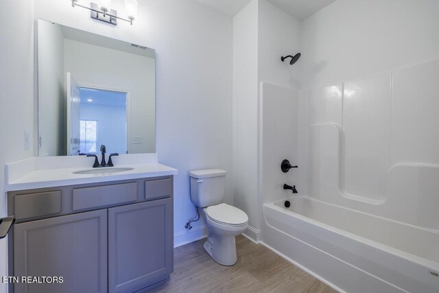 full bathroom featuring shower / bathing tub combination, vanity, hardwood / wood-style flooring, and toilet