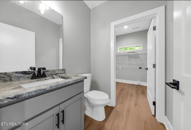 bathroom with hardwood / wood-style floors, toilet, and vanity