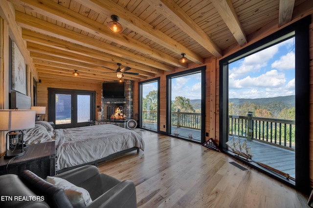 bedroom featuring beamed ceiling, french doors, wood ceiling, light hardwood / wood-style flooring, and access to exterior