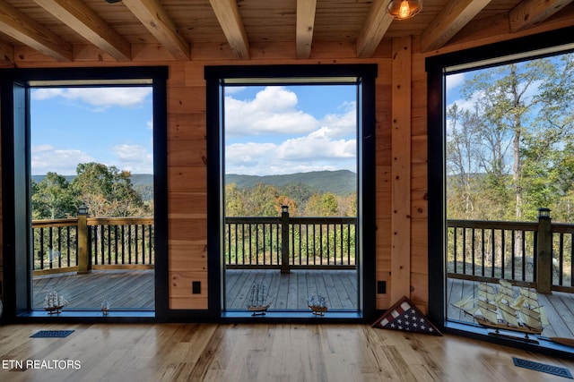 doorway featuring wood-type flooring, wooden ceiling, beam ceiling, and a mountain view